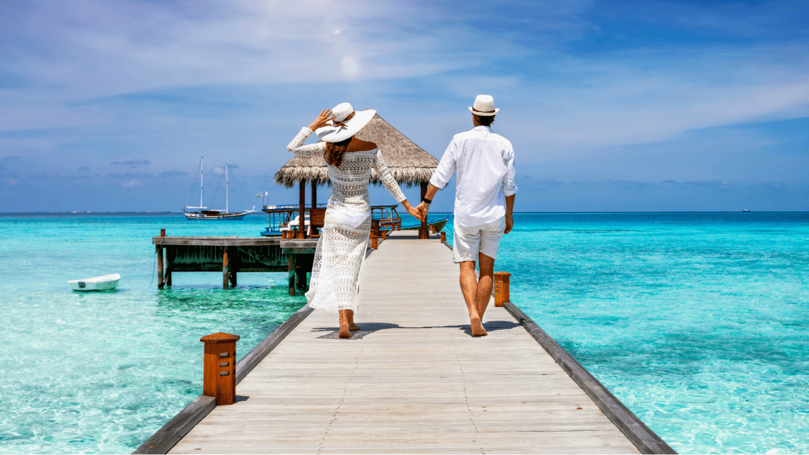 a couple walking towards the sea on a luxury trip